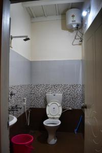 a bathroom with a toilet and a sink at Rochas Valley Homestay in Suntikoppa