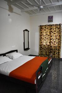 1 dormitorio con 1 cama grande y espejo en Rochas Valley Homestay, en Suntikoppa