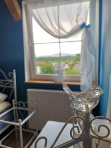 a glass bird sitting on a table in front of a window at Widok na Śnieżkę in Miłków