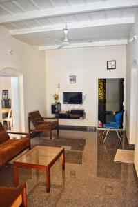 sala de estar con sofá y TV en Rochas Valley Homestay, en Suntikoppa