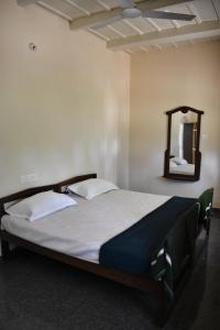 ein großes Bett in einem Zimmer mit Spiegel in der Unterkunft Rochas Valley Homestay in Suntikoppa