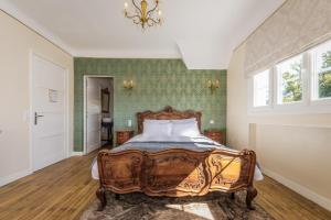 um quarto com uma cama de madeira e uma janela em Villa Verte em Saint-Mathieu