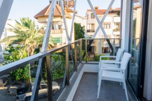 a balcony with white chairs and a view of a building at Pera Side Hotel in Side