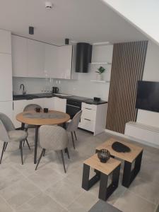 a kitchen with a table and chairs in a room at Luksusowy Apartament EDITH Giżycko in Giżycko