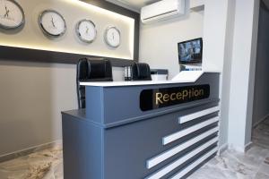 a reception desk with clocks on the wall at Pera Side Hotel in Side