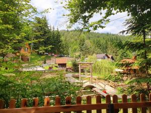 um jardim com uma ponte e uma cerca de madeira em Etno selo BISTROVO em Vitez