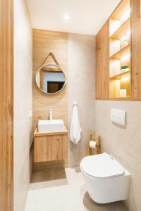 een badkamer met een wit toilet en een wastafel bij Domki Wilcze Pole in Waksmund