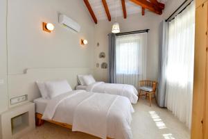a bedroom with two beds and a chair and a window at Sojoy Villa Allure in Fethiye