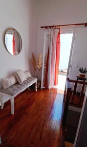 a living room with a couch and a mirror at Cycladic Maisonette (Dryopida, Kythnos) in Kithnos