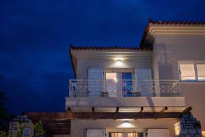 a white house with a balcony at night at Villa San Adriano in Nafplio