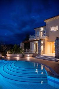 uma villa com piscina à noite em Villa San Adriano em Nafplio