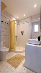 a bathroom with a sink and a toilet and a shower at Cycladic Maisonette (Dryopida, Kythnos) in Kithnos