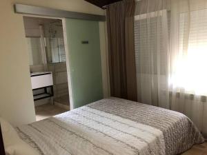 - une chambre avec un lit et une salle de bains pourvue d'un lavabo dans l'établissement Tranquil House Perfect for Vacations, à el Mas Vila