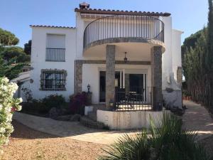 Cette grande maison blanche dispose d'un balcon. dans l'établissement Tranquil House Perfect for Vacations, à el Mas Vila