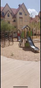 un patio de recreo con un tobogán en un parque en IFRANE, en Ifrane 2 fotos más