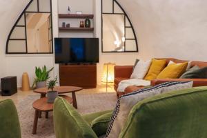 a living room with two couches and a tv at Cozy Heritage Home Jerusalem in Jerusalem