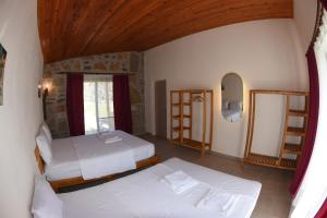 - une chambre avec 2 lits et un miroir dans l'établissement Begonvillage Tatil Evleri, à Datça