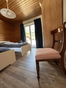 um quarto com uma cama, uma cadeira e uma janela em Ferienhaus Abendfrieden em Mittenwald