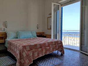 1 dormitorio con 1 cama y vistas al océano en Hotel Aurora Nord, en Rímini