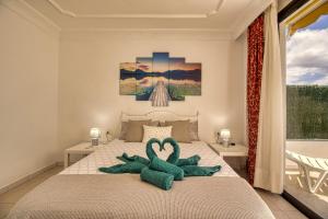Un dormitorio con una cama con dos cisnes. en Luxury Penthouse Sea View Jacuzzy & pool wiffi free en Playa Fañabe