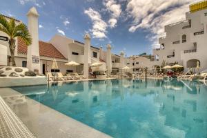 duży basen przed budynkiem w obiekcie Luxury Penthouse Sea View Jacuzzy & pool wiffi free w mieście Playa Fañabe