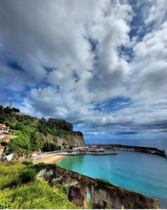 Ein Strand mit einem Haufen Boote im Wasser in der Unterkunft VIVIENDA VACACIONAL "EL CANXILÓN" Situada en Lastres - Zona Oriente de ASTURIAS - Casa independiente - Terraza con vistas al mar a 800 m de la playa in Llastres