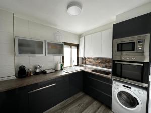 a kitchen with a washing machine and a microwave at KB HOME Puertollano in Puertollano
