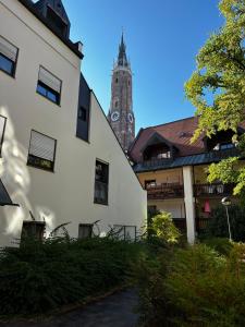 un bâtiment avec une tour d'horloge en arrière-plan dans l'établissement Wohnung in Landshuter Altstadt, à Landshut