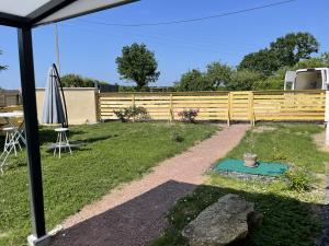聖馬丁拉迪拉帕的住宿－Saumur, proche, les 3 gîtes，后院设有围栏、桌子和雨伞