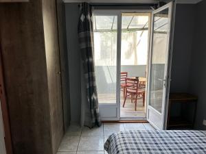 Habitación con cama y puerta corredera de cristal en Logement meublé avec terrasse, en Vincennes