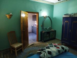 1 dormitorio con paredes verdes, 1 cama y espejo en Gabawy Garden Ferienwohnung, en Luxor