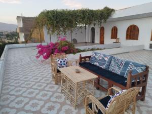 un patio con sofá, mesas y sillas en Gabawy Garden Ferienwohnung en Luxor