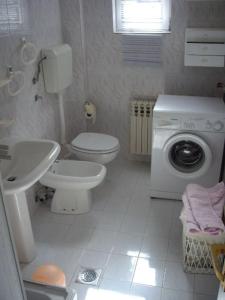 a bathroom with a toilet sink and a washing machine at Downtown House with garden in Sarajevo