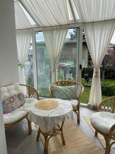 a living room with a table and chairs and a window at Downtown House with garden in Sarajevo