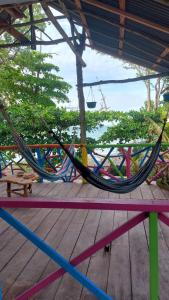 a hammock on a deck with a view of the ocean at Casa hostal playa coral in Capurganá