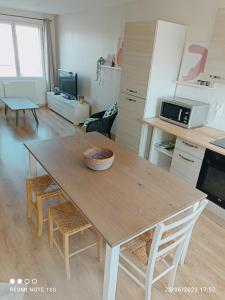 a kitchen with a wooden table with chairs and a table at Spacieux appartement en duplex in Merlimont