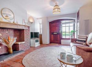a living room with a couch and a fireplace at Carpenters Cottage Quirky home Seaside town in Minehead