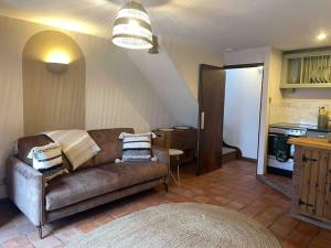 a living room with a couch and a kitchen at Carpenters Cottage Quirky home Seaside town in Minehead