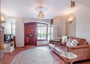 a living room with a couch and a tv at Carpenters Cottage Quirky home Seaside town in Minehead