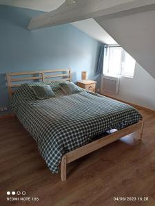 a bedroom with a bed with a checkered blanket at Spacieux appartement en duplex in Merlimont