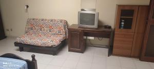 een kamer met een stoel en een tv op een bureau bij alloggio greenpark in Milazzo