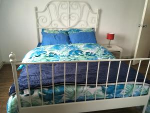 a white bed with a blue and white comforter at The Crescent in Barking