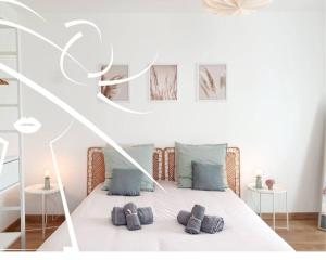 um quarto com uma cama branca com três almofadas em La Suite N°05 par Madame Conciergerie em Rennes