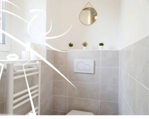 a bathroom with a toilet and a light fixture at La Suite N°05 par Madame Conciergerie in Rennes