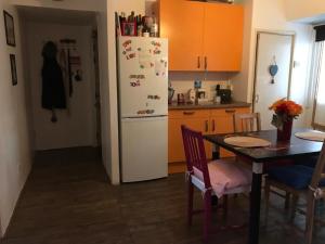 uma cozinha com uma mesa e um frigorífico branco em The Crescent em Barking