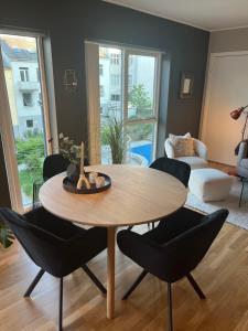 - un salon avec une table et des chaises en bois dans l'établissement Modern Apartment - Amazing Terrace and Fjord View, Close to City Center, à Bergen