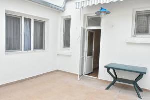 una mesa en la esquina de una pared blanca con ventanas en Trimaya apartment - comfort in the top city center, en Varna