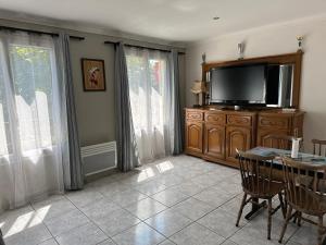 sala de estar con TV de pantalla plana y mesa en Logement meublé avec terrasse, en Vincennes