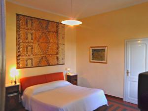 カポテッラにあるVilla Giardiniのベッドルーム1室(ベッド1台付)が備わります。壁には絵画が飾られています。