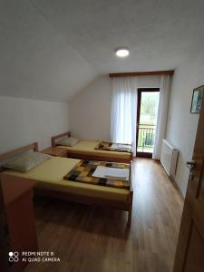 een kamer met 2 bedden in een kamer met een raam bij Apartment Savkovic in Šipovo